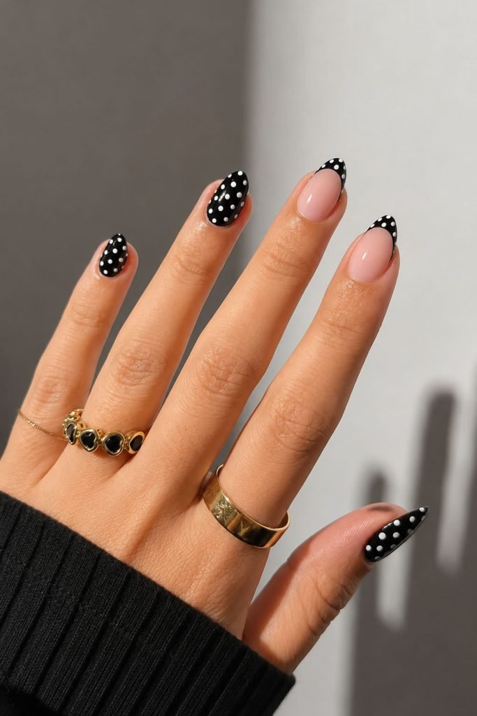 Black and white spotted nail designs with trendy polka dot nail art on glossy almond-shaped nails