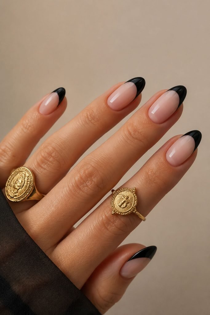 Classic black French manicure with glossy black tips over a nude base for an elegant minimalist nail look