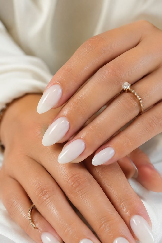 Milky white nails with glossy sheer finish on elegant almond-shaped nails