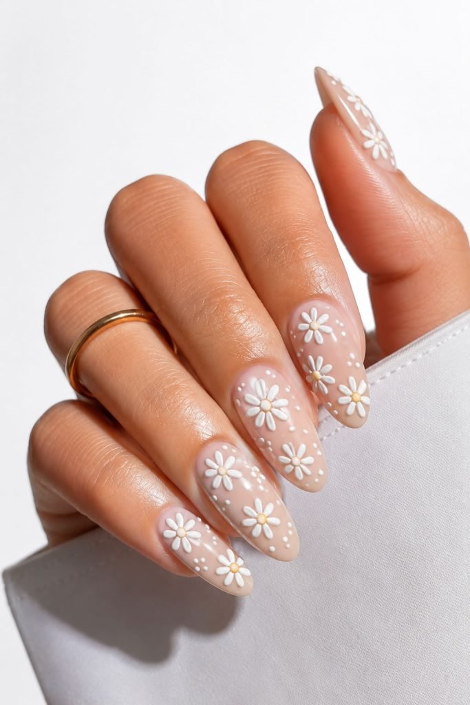 nails with cute daisy designs on a soft neutral manicure