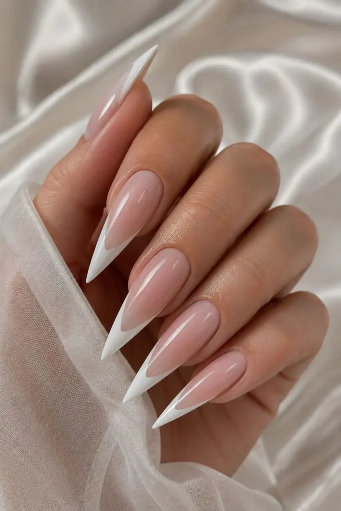 Long stiletto white nails with a sheer nude base