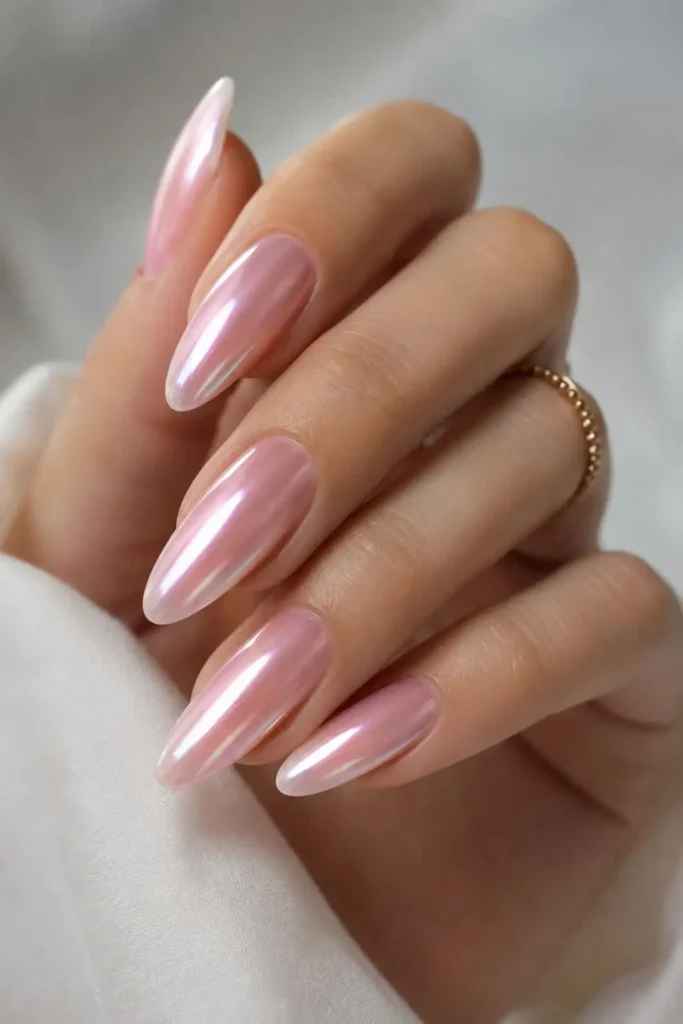 Soft light pink chrome almond nails with a subtle glassy shimmer