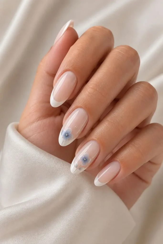 White French nails with delicate blue floral nail art