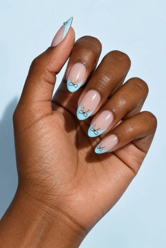 Baby blue coquette bow nails designs with silver ribbons and rhinestone accents