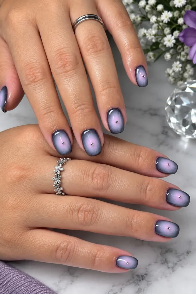 Black and vampy aura nails with deep wine tones and subtle rhinestone accents