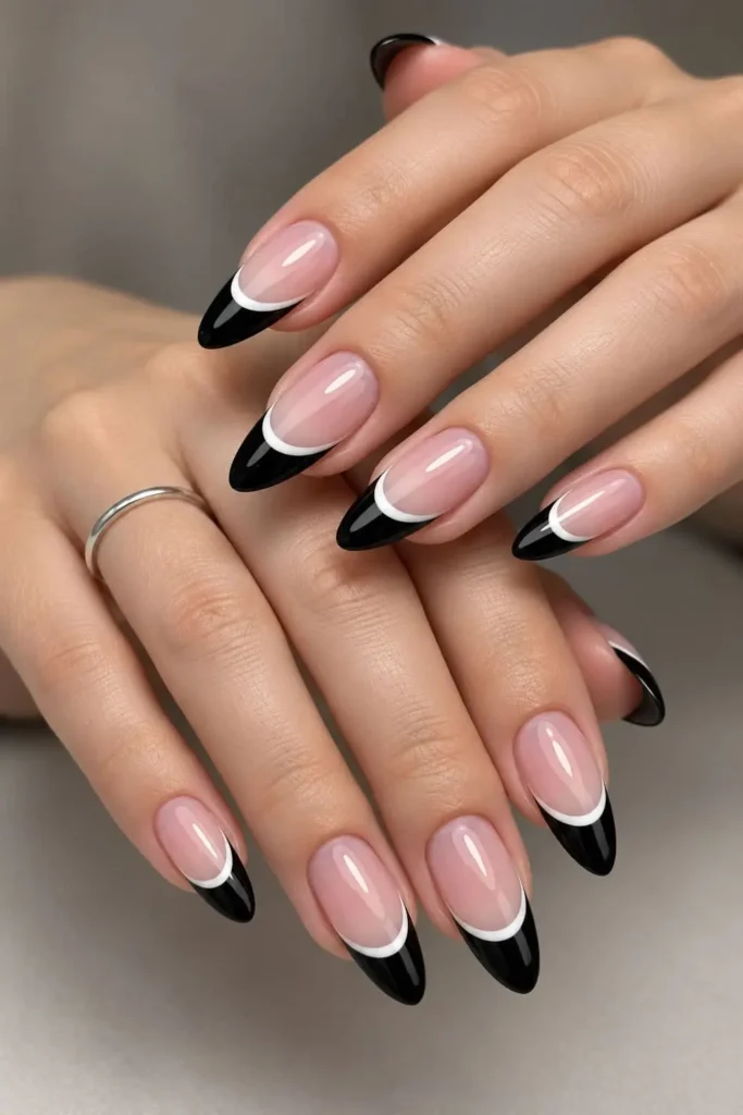 Black and white French tip nails with a classic white base and thin black tips