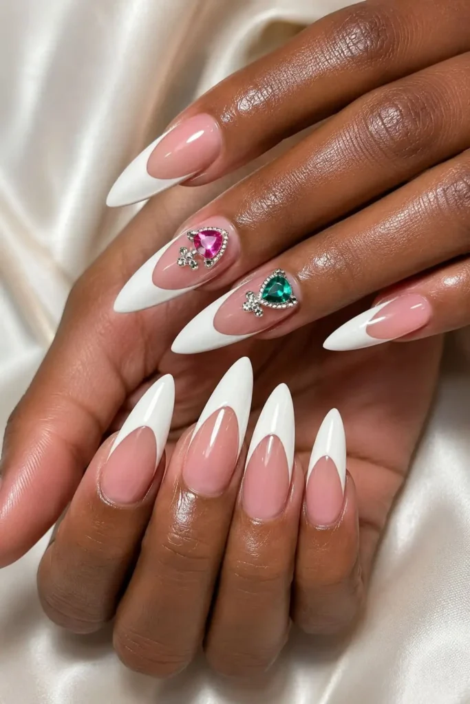 Blinged-out accent nails with sparkling charms over a neutral manicure
