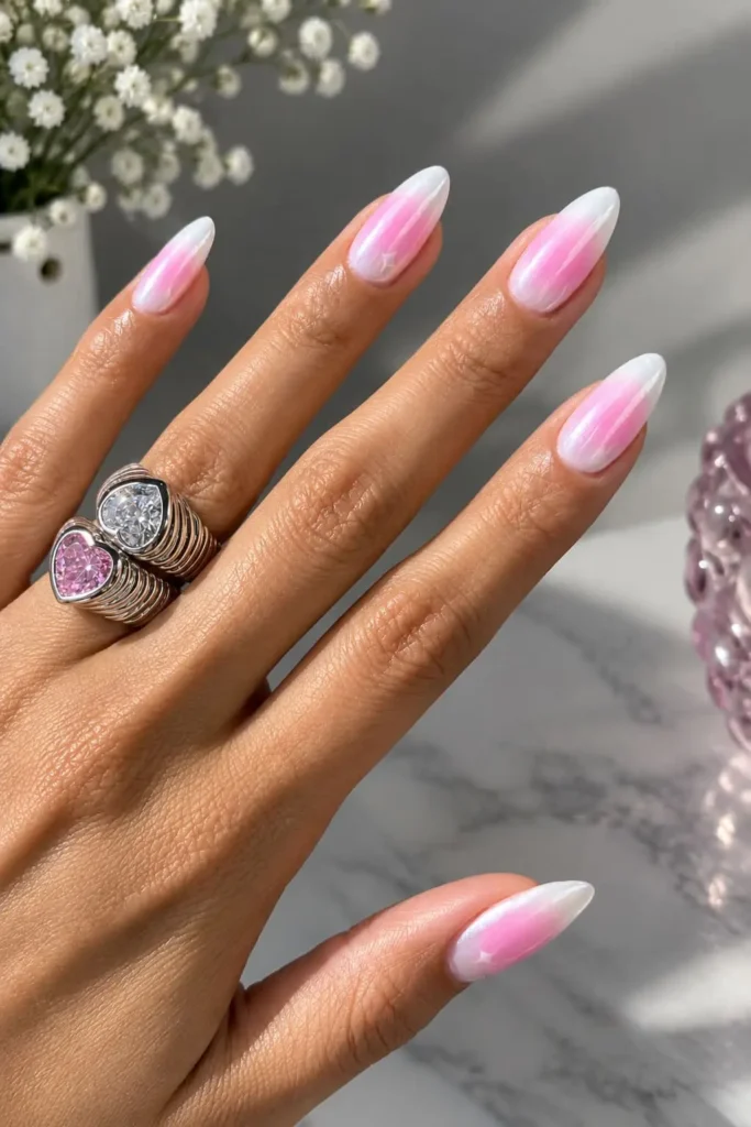 Blushing pearl aura nails with a nude base, rosy center and pearly white accents