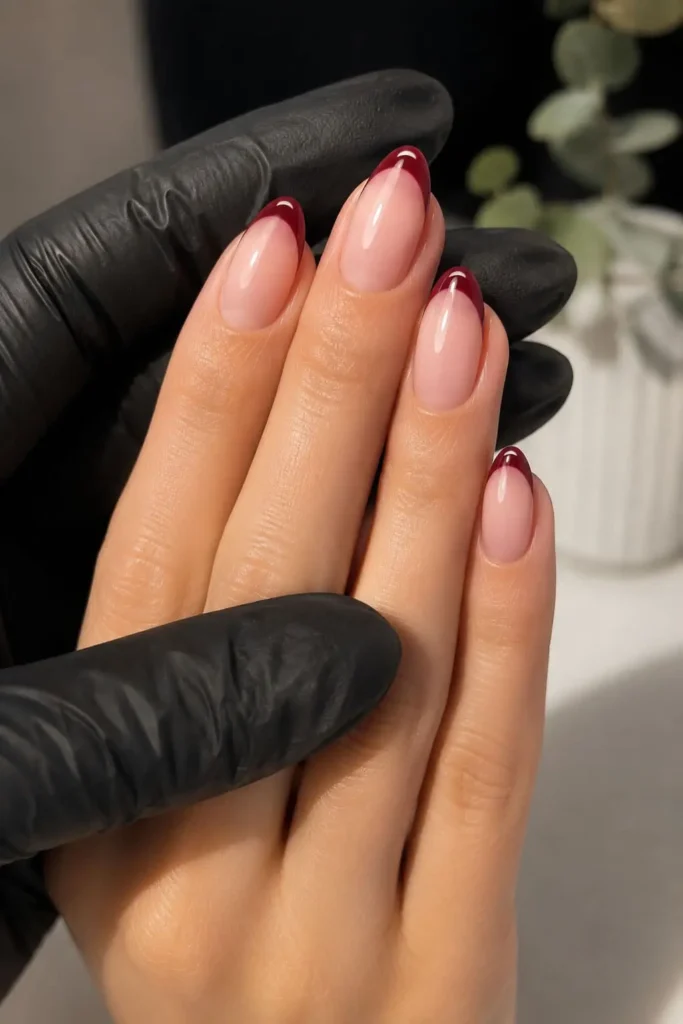 Burgundy French manicure with thin dark red tips on a neutral base