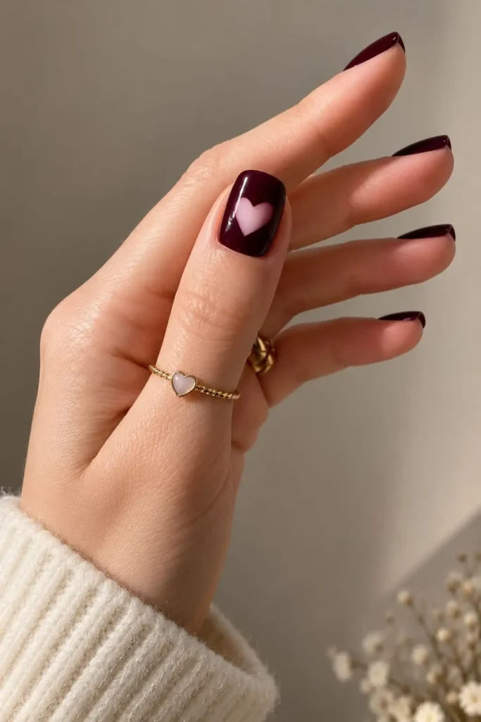 Burgundy heart nails with delicate negative space heart nail art