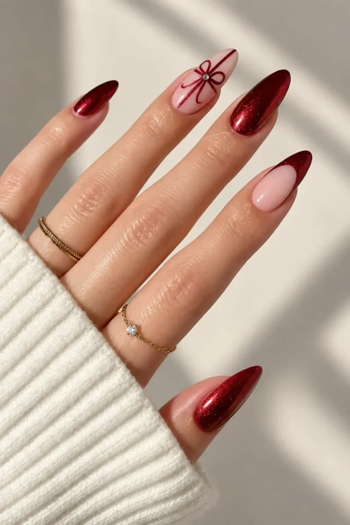 Red metallic Christmas nails with bows, gems, and festive ornament accents