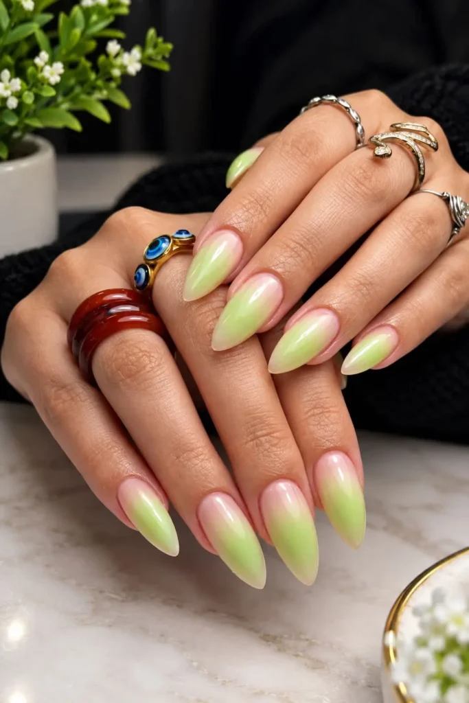 Green aura nails with a hazy green glow, nude base and tiny white starbursts