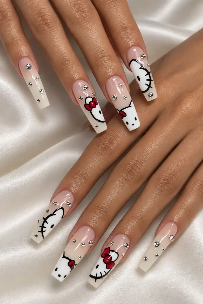 Hello Kitty coffin nails with pastel polish, red bows and silver rhinestone accents