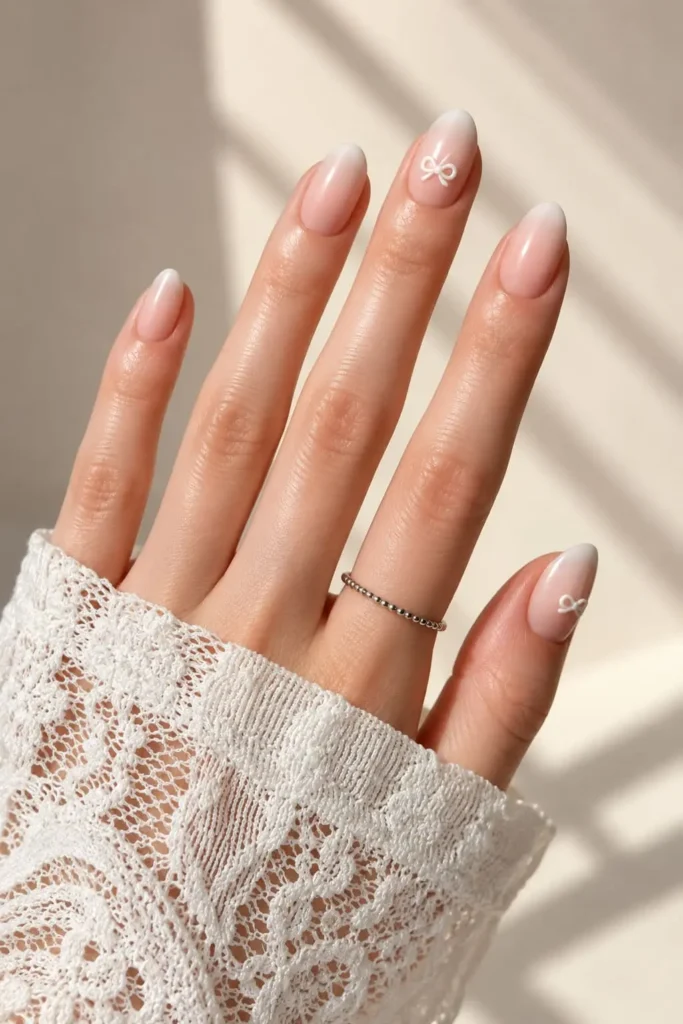 Jennie-inspired pink bow nails with pearl accents and delicate coquette details