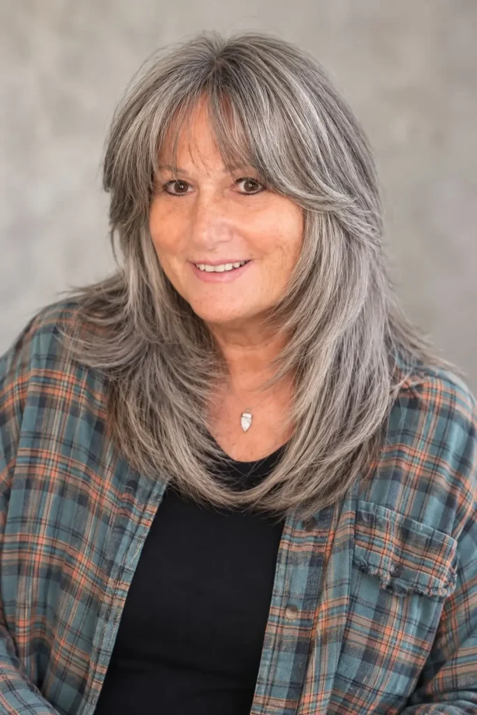 Layered haircut for women over 60 with thick hair and curtain bangs