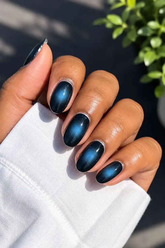 Moody blue and black aura gel nails with a dimensional effect
