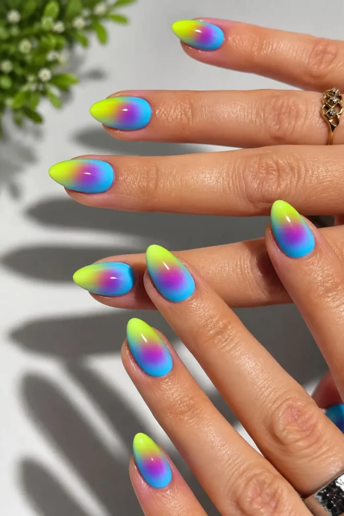Neon aura nails with electric violet, sky blue and bright yellow glowing gradients