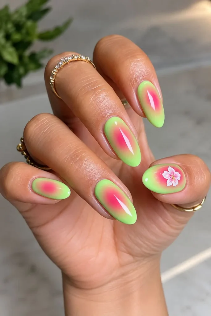 Pink and green aura nails with a lime green base, soft pink center and floral accent