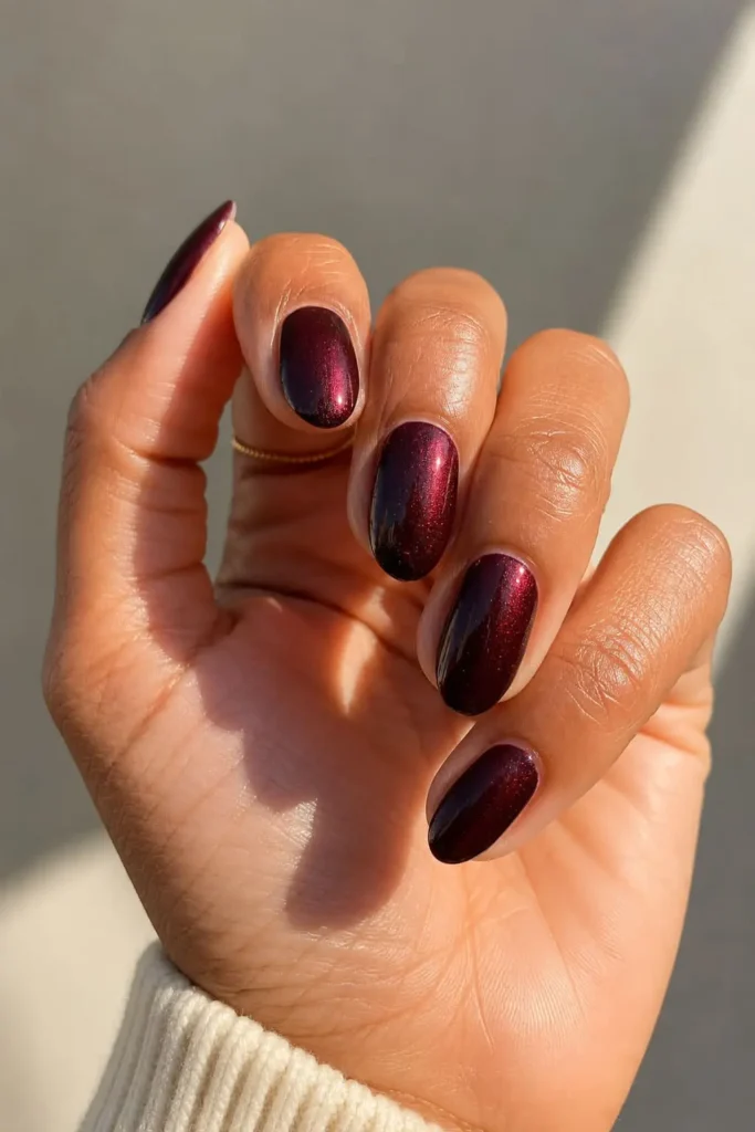 Shimmer burgundy nails with subtle reflective details over deep red polish