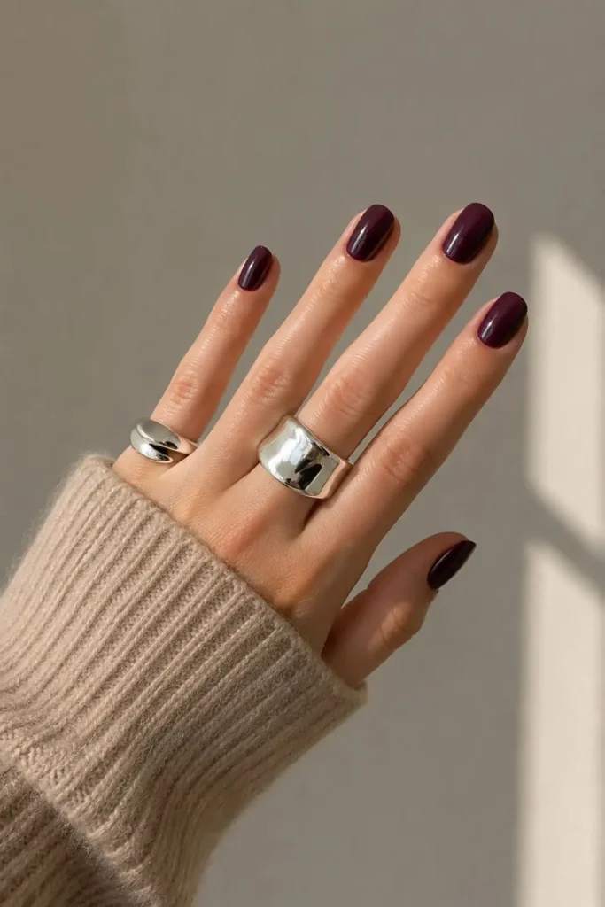 Short oval acrylic nails with a bold glossy red polish finish