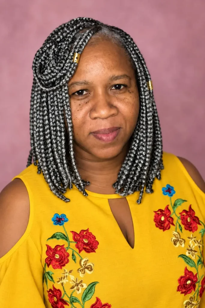 Short cornrows hairstyle with a side part for Black women over 50